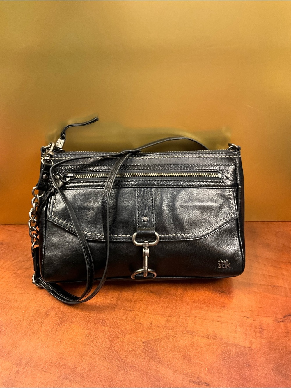 The Sak Black Leather Crossbody with Front Clasp and Chain Detail